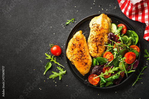 Fresh salad with chicken fillet and vegetables on black. Healthy food.