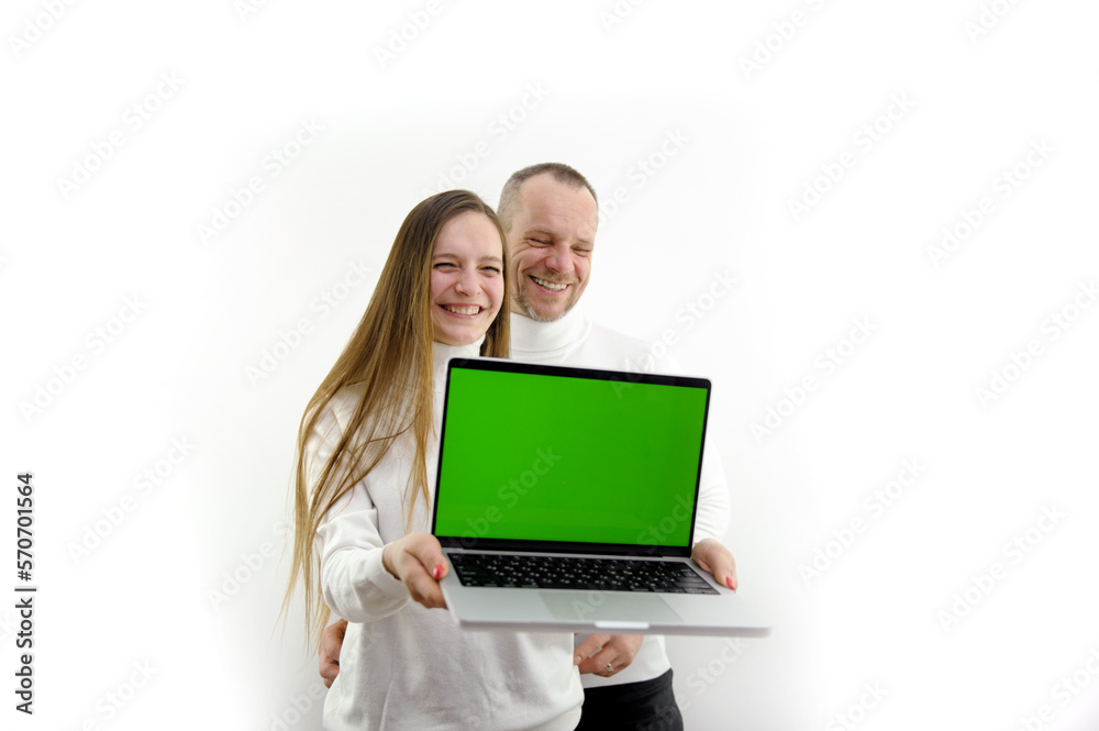 man and woman are very happy happiness smile sincere laughter in white clothes in hands laptop with green screen chromakey empty space for text sincere beautiful photo business purchase gift man and woman are very happy happiness smile sincere laughter in white clothes in hands laptop with green screen chromakey empty space for text sincere beautiful photo business purchase gift