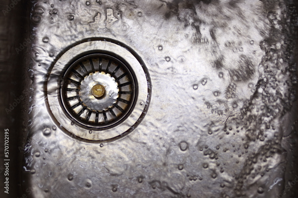 A close-up of metal sink with running water.