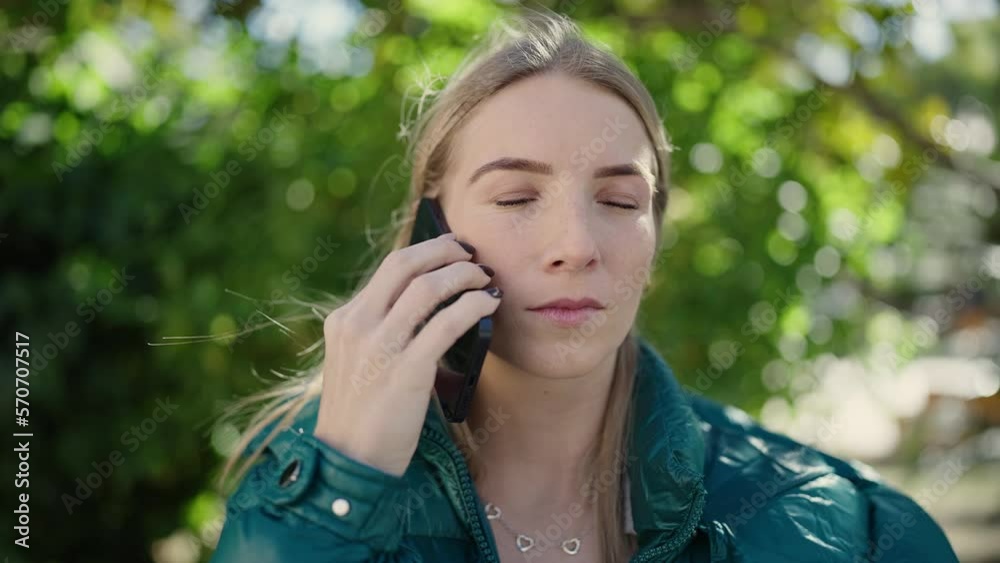 Young blonde woman speaking on the phone at park Young blonde woman speaking on the phone at park