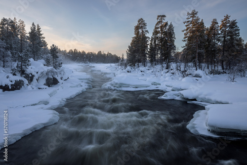 Half frozen River Juutanjoki with rapids in winter, Inari, Lappland, Finland
