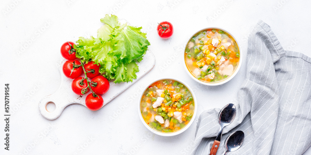 Light vegetable soup with chicken, corn and green beans. Comfort food. White table background, top view banner