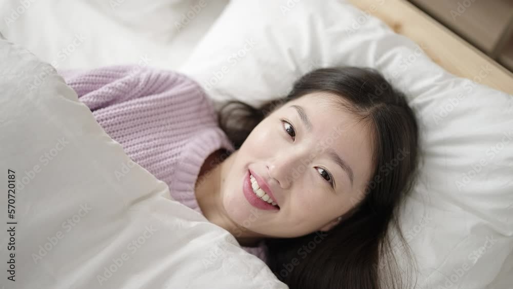 Young chinese woman smiling confident lying on bed at bedroom Young chinese woman smiling confident lying on bed at bedroom