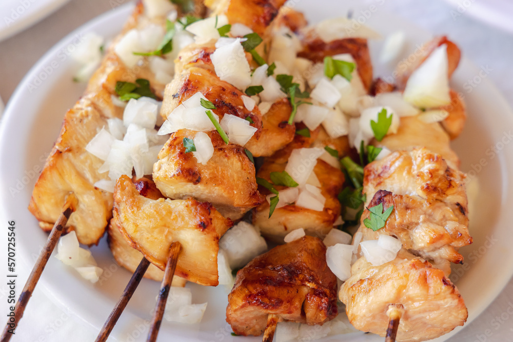 Greek Chicken Souvlaki shashliks with onion on a plate Cyprus island country Greek Chicken Souvlaki shashliks with onion on a plate Cyprus island country