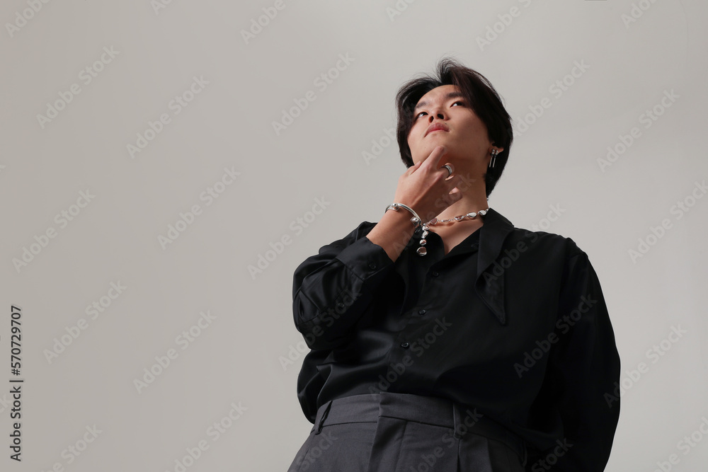 Confident young Asian man posing indoor over white background. Mock-up.