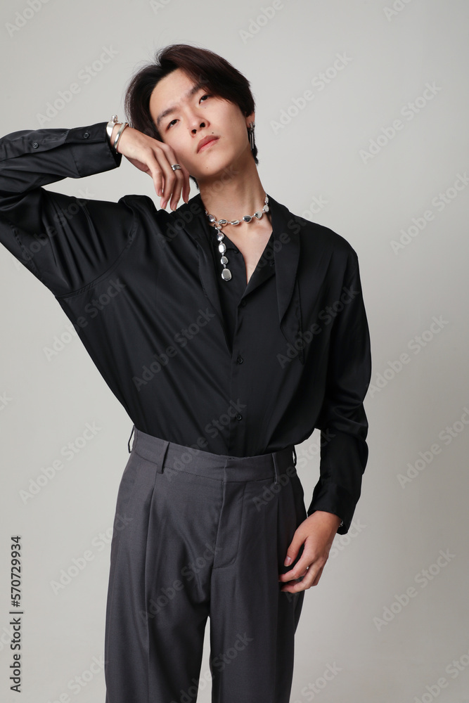 Confident young Asian man posing indoor over white background. Vertical mock-up. Confident young Asian man posing indoor over white background. Vertical mock-up.