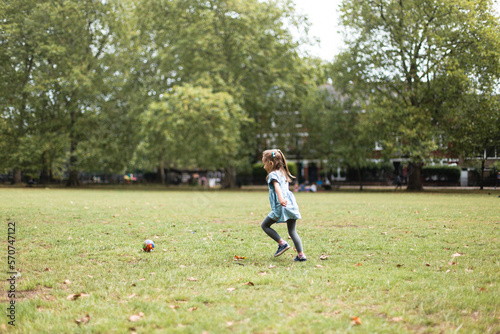 Little girl playing football in the park