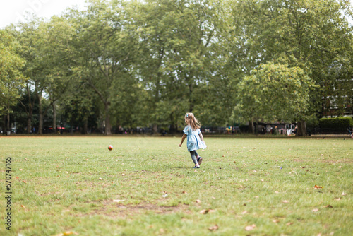 Little girl playing football in the park