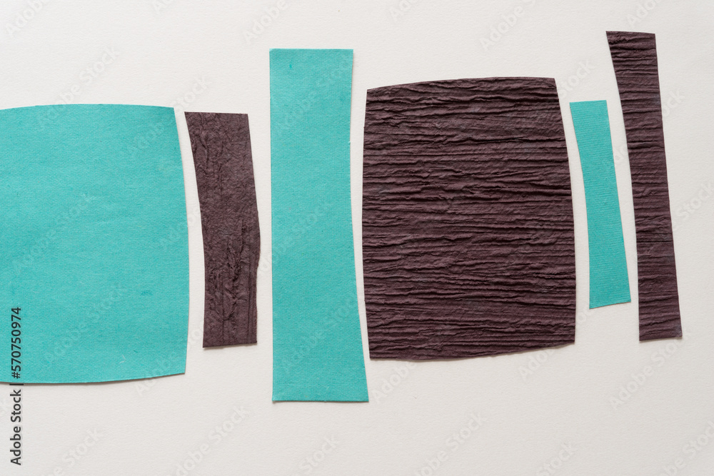 Naklejka premium blue and brown paper stripes and squares on blank paper