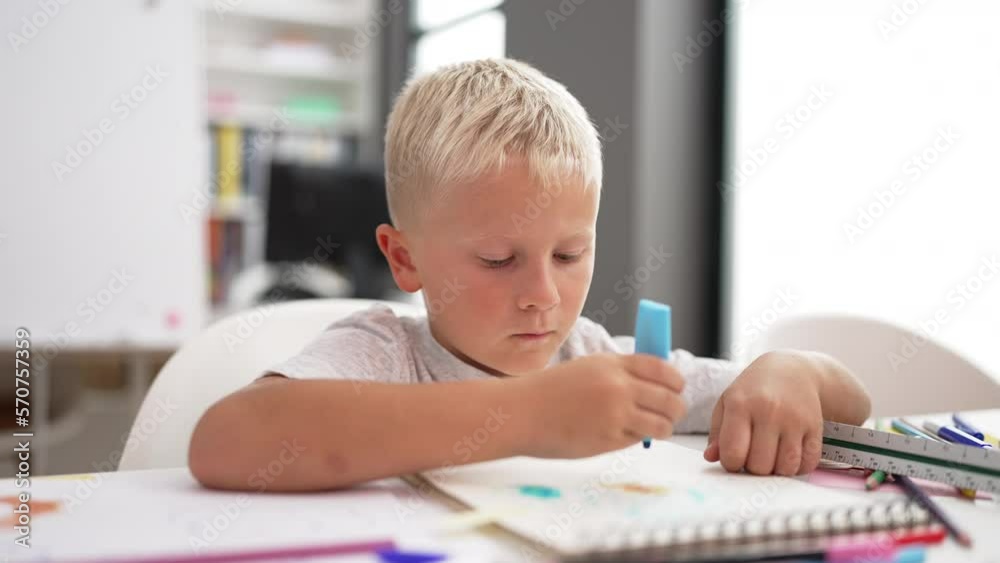 Adorable toddler student drawing on notebook doing ok gesture at classroom Adorable toddler student drawing on notebook doing ok gesture at classroom