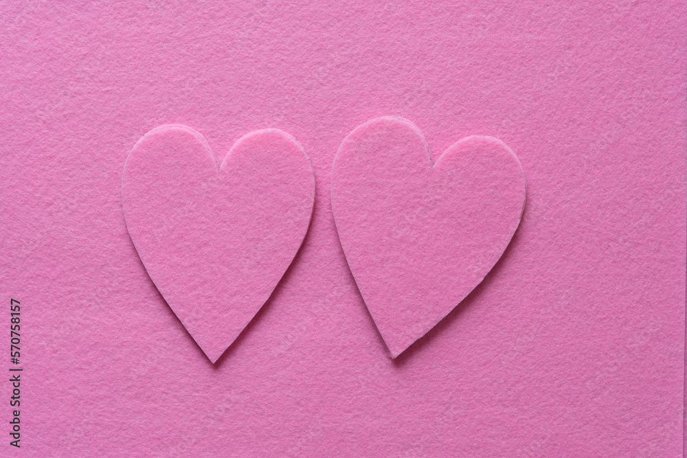 two piles of pink felt hearts on pink felt ground