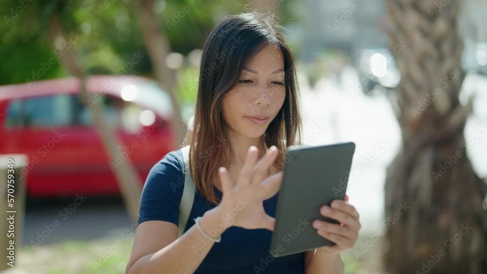 Young asian woman smiling confident using touchpad at street Young asian woman smiling confident using touchpad at street