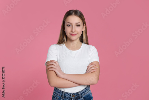 Portrait of beautiful teenage girl on pink background