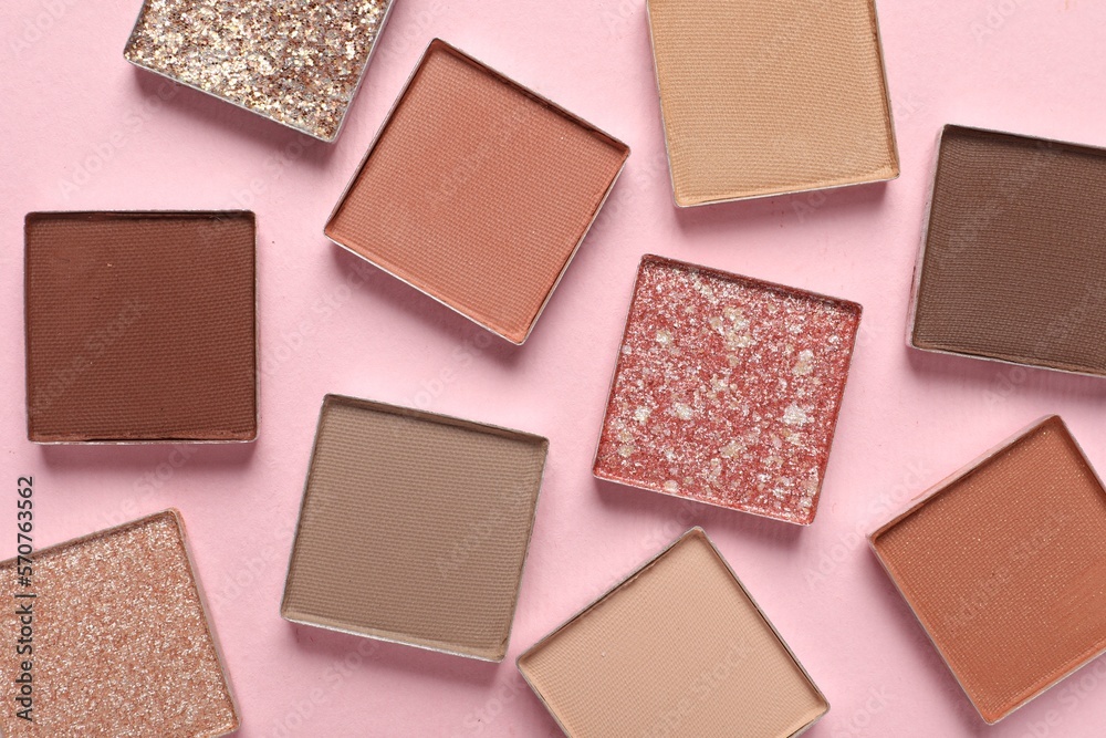 Fototapeta premium Different beautiful eye shadows on pink background, flat lay