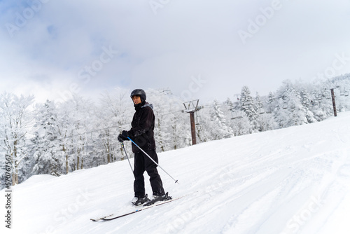 Young Asian man with practicing skiing on snowy mountain slope at in ski resort. Handsome guy enjoy winter activity outdoor active lifestyle extreme sport training freeride ski on holiday vacation.