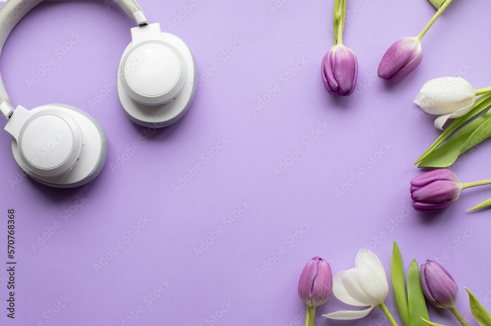 Wireless headphones and Spring tulips on violet background 