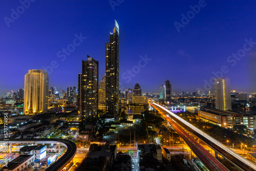 Cityscape of Bangkok after sunset in blue hour with skyscraper and city view with road and traffic light.