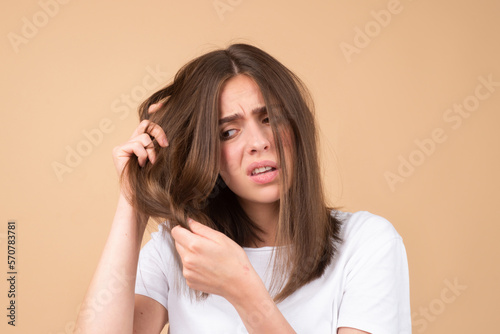 Sad girl looking at damaged hair, the hair loss problem. Isolated, copy space.
