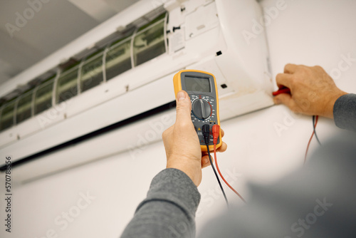 Air conditioner, maintenance hands and voltage meter with construction, wall and technician man. AC repair, professional hvac expert and handyman with digital reading, analysis or engineering service