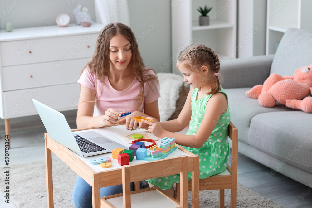 Little girl and her mother with toys having online psychologist session at home Little girl and her mother with toys having online psychologist session at home