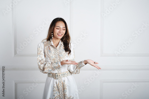 Asian girl pointing to empty space with the hand and fingers. 