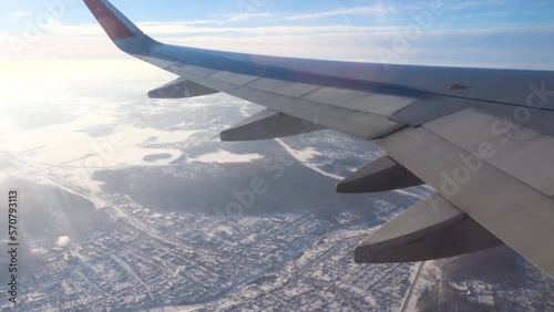 View from an plane window. Airplane flying over a snow-covered city. The concept of traveling by aircraft.