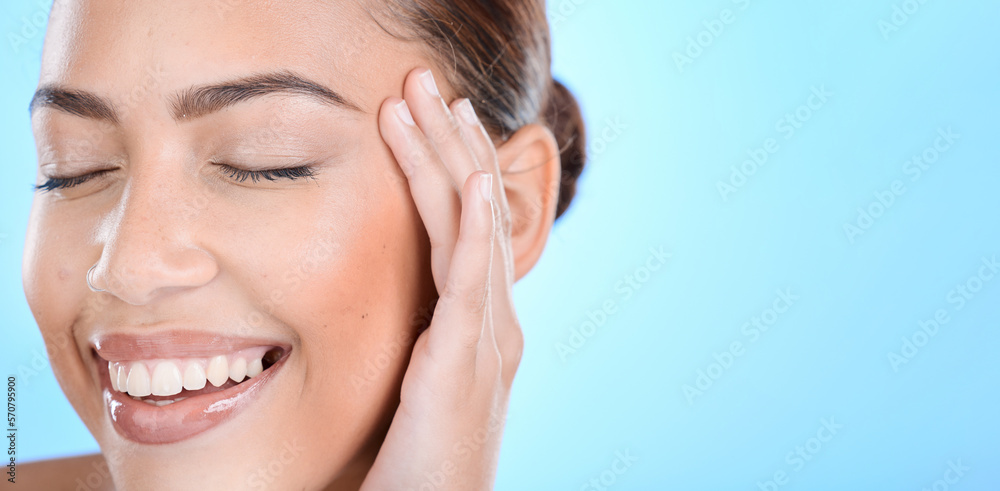 Fototapeta premium Woman, skincare and hands on face in studio for makeup, wellness or gentle cleaning on blue background. Face, beauty and girl skin model relax in luxury, facial and cosmetic treatment while isolated