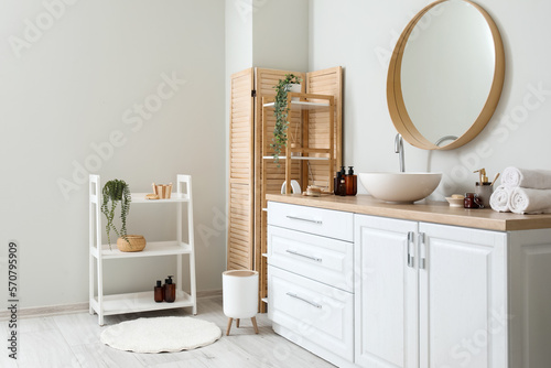 Interior of light bathroom with counters, sink and mirror © Pixel-Shot