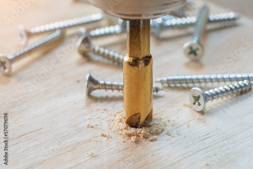 Obraz na płótnie Carpenter use countersink bit to drill both a pilot hole and use countersink bit to recess the head of the screw into wood plank. DIY maker and woodworking concept. selective focus w salonie