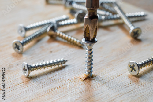 Obraz na płótnie Screwdriver drill a screw into wood plank ,DIY maker and woodworking concept. selective focus w salonie