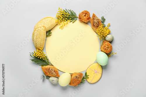 Blank card with flowers, eggs and treats on grey background. Novruz Bayram celebration photo