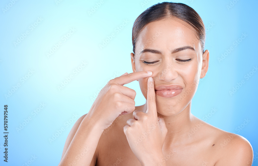 Skincare, acne and face of woman with pimple on blue background for wellness, beauty and self care. Dermatology, cosmetics and girl with hands to pop blackhead, skin blemish and facial treatment Skincare, acne and face of woman with pimple on blue background for wellness, beauty and self care. Dermatology, cosmetics and girl with hands to pop blackhead, skin blemish and facial treatment