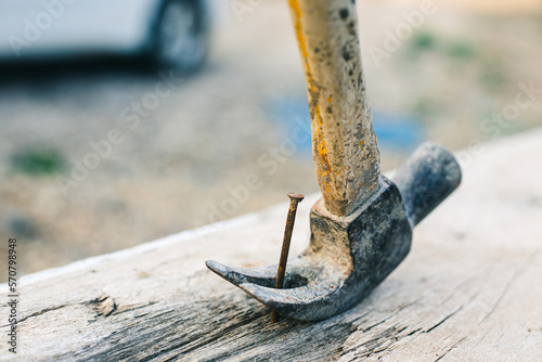 Using rusty hammer and nail on wood and blur background. Tools of wood work. Detail of a nail and a hammer. Hammer and nails on wood. copy space for text. construction concept.