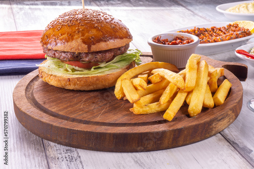 Big sandwich - hamburger with juicy beef burger  cheese  tomato  and red onion on wooden background