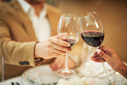 Toast, wine and hands of couple in restaurant for romantic dinner, date and anniversary celebration. Relationship, fine dining and man and woman cheers together for social drinks, alcohol and relax