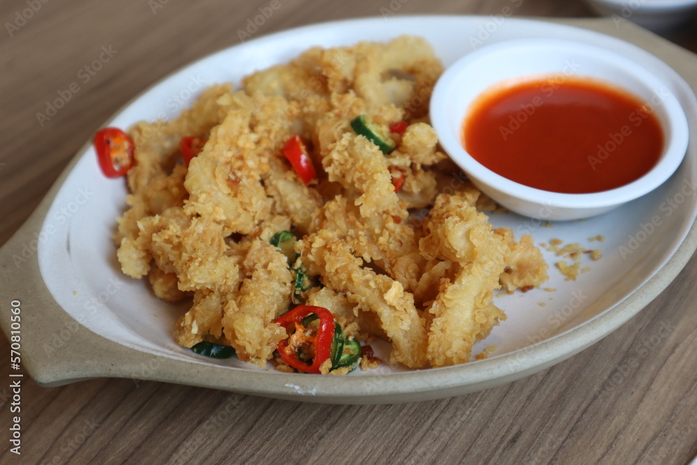 Deep-fried Calamari with Salt and Chili on white plate served with spicy sauce. Deep-fried Calamari with Salt and Chili on white plate served with spicy sauce.