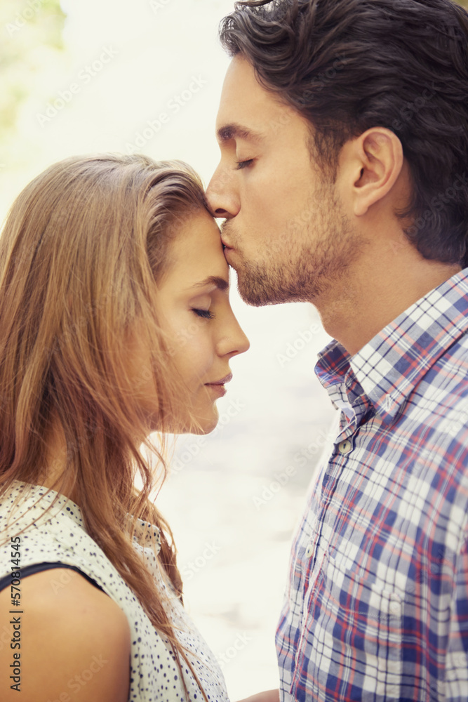 Kiss, affection and couple with love in nature on a date, bonding and loving in a relationship. Content, romance and man kissing a woman on the forehead during valentines day at a park in Italy