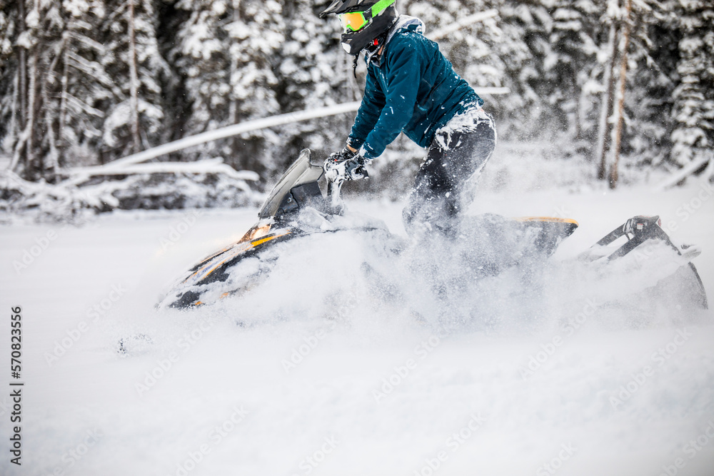 Side view of man snowmobiling through deep snow. Side view of man snowmobiling through deep snow.