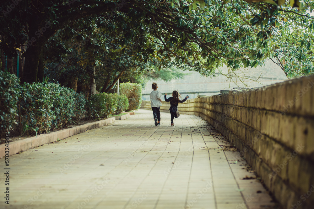 two happy kids running away from the camera two happy kids running away from the camera