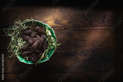 Cedar oil and pine cones on wooden background photo