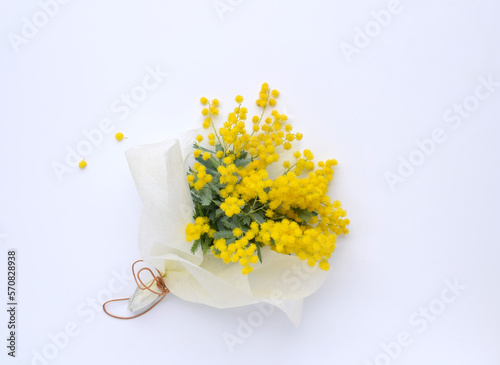 白いテーブルに載せたミモザの花束、アカシアのブーケ