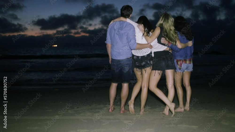 Friends look out towards ocean Friends look out towards ocean