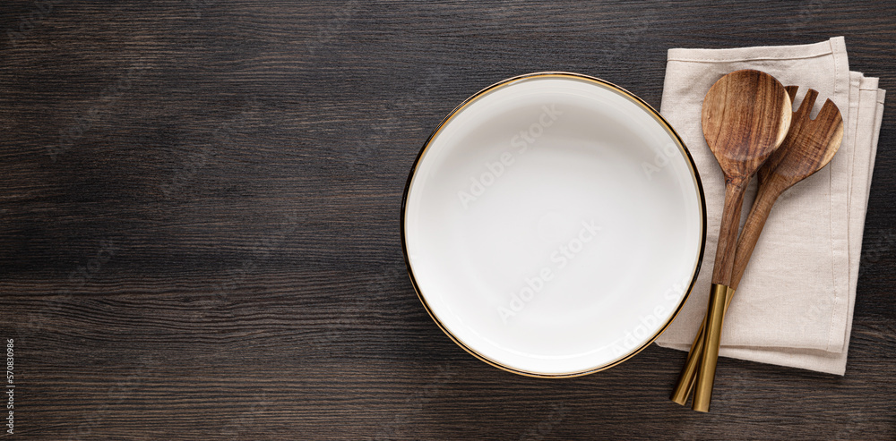An empty large salad bowl with utensils on a linen napkin An empty large salad bowl with utensils on a linen napkin
