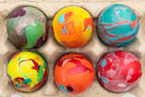 Composition de Pâques avec des œufs de poules colorés rangés dans une boite à œufs. Concept de fêtes de Pâques. Vue de dessus.	