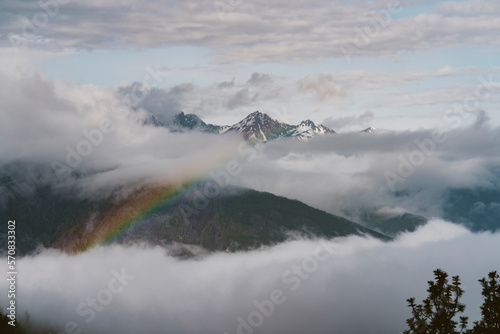 A rainbow appears in the clouds after a rain storm in the mountains photo