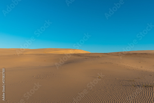 Empty sand dune with blue sky.