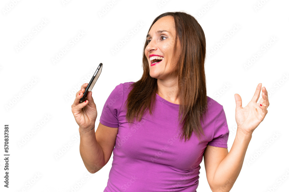 Middle-aged caucasian woman over isolated background using mobile phone and singing Middle-aged caucasian woman over isolated background using mobile phone and singing