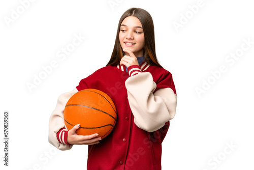 Teenager girl playing basketball over isolated chroma key background looking to the side and smiling © luismolinero