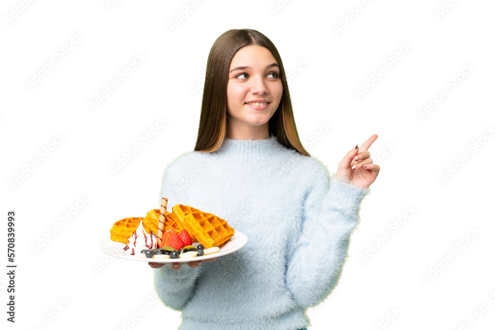 Teenager girl holding waffles over isolated chroma key background pointing up a great idea Teenager girl holding waffles over isolated chroma key background pointing up a great idea