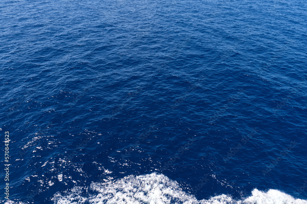 blue ocean with boat sailing foam, sea surface texture